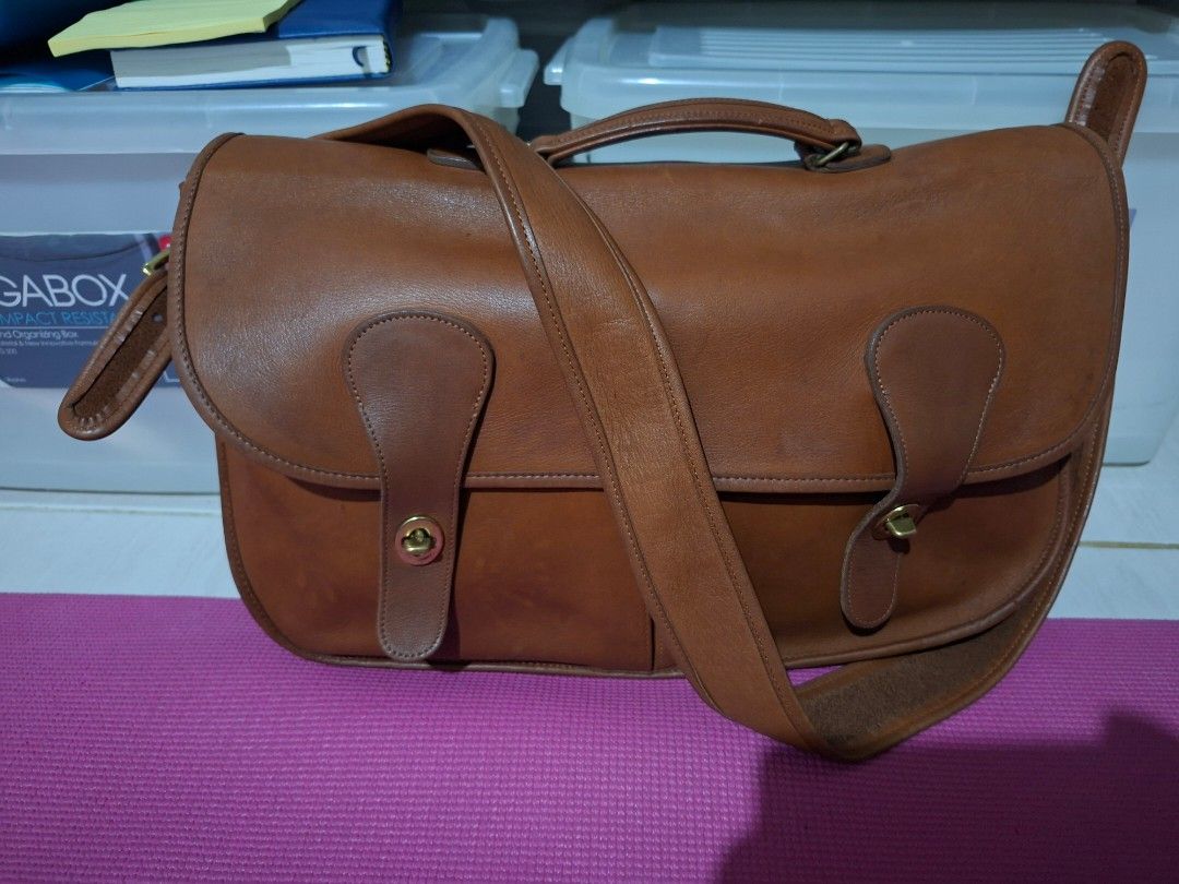 Vintage Coach Musette (Category: Luxury Bags & Wallets) located in Cabanatuan. Submitted by thriftytrix (Listing ID 1467259170, Image 1). Description: - Material: Premium deep brown/tan leather with clean edge stitching - Closure: Dual front flaps with secure turn-lock - Hardware: Durable brass accents on the top carry handle - Structure: Holds its shape well with reinforced side panels - Style: Professional briefcase, perfect for work or daily c