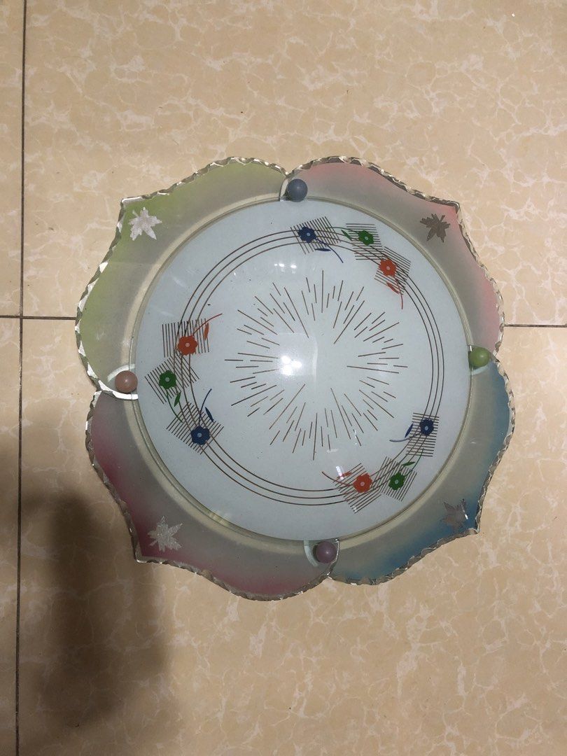 Cute ceiling light cover (Category: Lighting) located in Cavite. Submitted by ai__chang (Listing ID 1467407148, Image 1). Description: - Type: Round glass ceiling light cover - Design: Colorful floral patterns with geometric grid accents - Border: Gradient pastel tones and scalloped edges with small decorative balls - Center: Delicate radiating line pattern - Condition: Clean, ready to install - Perfect for adding a vintage or cottagecore vibe to
