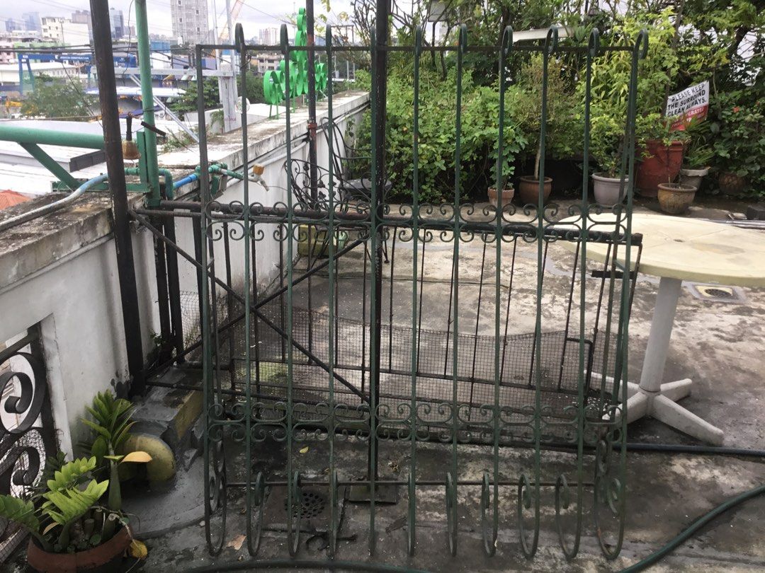 Vintage Green Wrought Iron Security Gate Grille (Category: Locks, Doors & Gates) located in Manila. Submitted by roberto.enriquez (Listing ID 1467588791, Image 3). Description: - Green wrought iron security gate - Elegant scrollwork details on top and bottom - Heavy metal construction with lower wire mesh panel - Standard door or window width - Ideal for home security upgrades or vintage garden decor - Condition: Has surface weathering and rust s