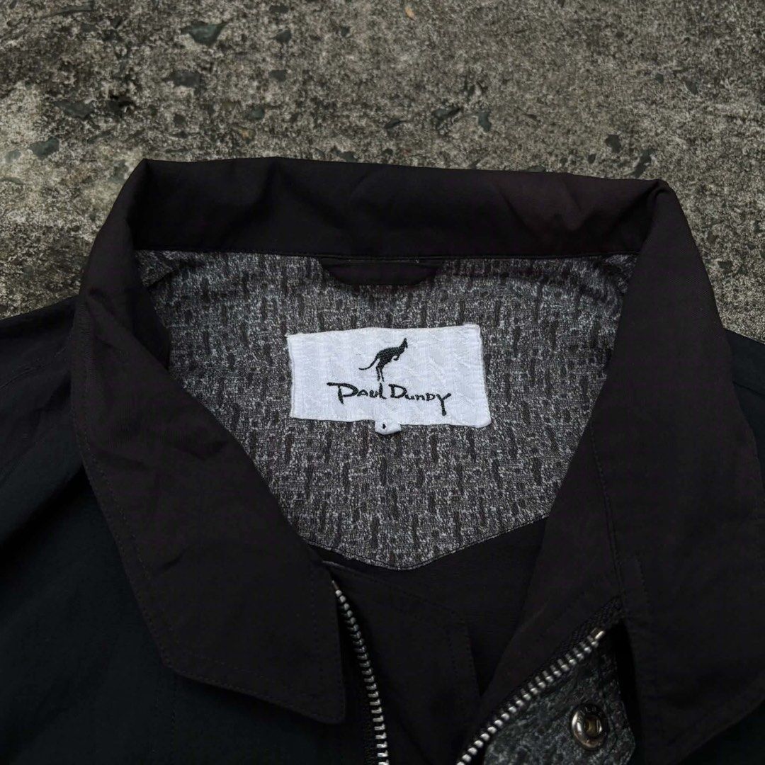 Vintage Paul Dundy Pilot Bomber Jacket (Category: Coats, Jackets and Outerwear) located in Manila. Submitted by vvyein_ (Listing ID 1467547309, Image 3). Description: - Brand: Paul Dundy (Japanese brand) - Color: Classic Black - Design: Embroidered kangaroo logo on the chest with stylish contrasting grey patterned inner collar and zipper trim - Pockets: Functional snap-button chest pockets - Fit: Classic bomber style with a ribbed hem and button 