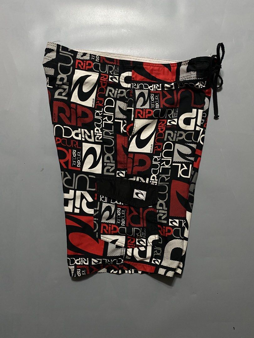Vintage Rip Curl Board Shorts (Category: Swim Trunks & Board Shorts) located in Manila. Submitted by delunakenn94368 (Listing ID 1467509323, Image 3). Description: - Authentic Rip Curl board shorts - Striking all-over logo print in black, red, and white - Secure drawstring waistband with lace-up closure - Convenient side cargo pocket with button flap - Lightweight, quick-dry fabric ideal for surfing, swimming, and beach days - Refer to tag for ex