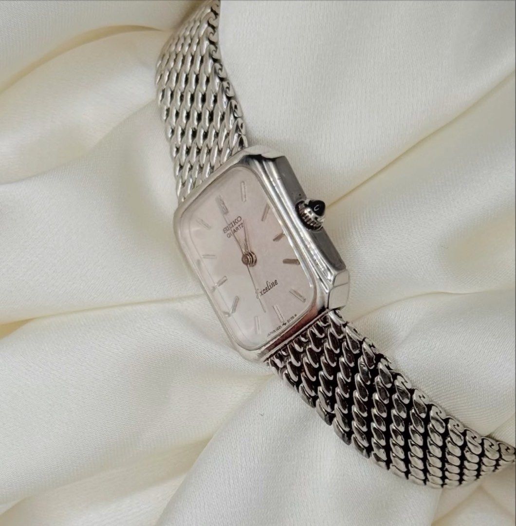 Vintage Seiko Exceline Silver Mini Tank Watch (Category: Women's Watches) located in Lipa City. Submitted by watchoutph (Listing ID 1467548671, Image 3). Description: 1982 Seiko Exceline "Whiteflake" Mini Tank Quartz pinched rectangular cushion case 17.7mm x 19.6mm 16cm wrist Beads of rice bracelet Stainless steel Stick indices 3 hands Textured Dial Black onyx crown 8/10 patina on the right edge of the dial ₱7,800.