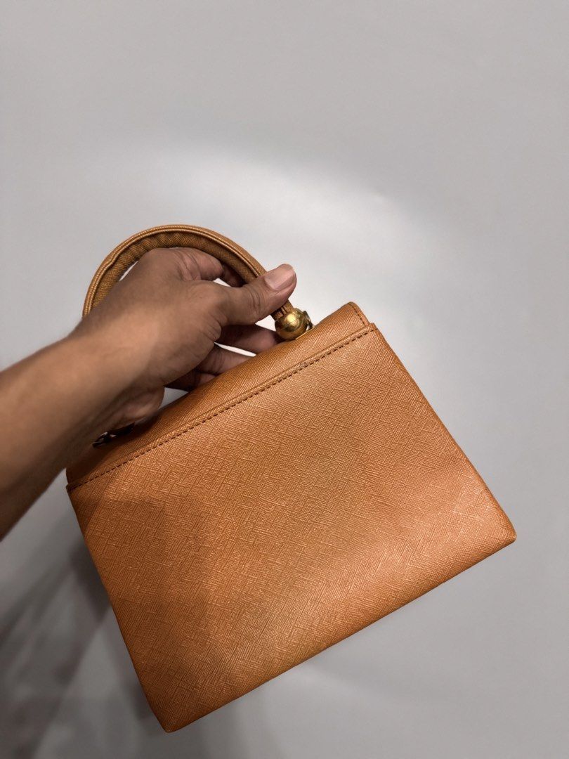 Vintage Tan Structured Top Handle Handbag Gold Hardware (Category: Luxury Bags & Wallets) located in Alaminos. Submitted by outfitcheck.ph (Listing ID 1467485254, Image 3). Description: - Color: Classic Tan - Material: Pebbled saffiano-style texture - Hardware: Elegant gold-tone metal balls - Closure: Secure front flap turn-lock - Interior: Smooth cream-lined flap - Size: Compact, ideal for daily essentials - Condition: Clean stitching throughout