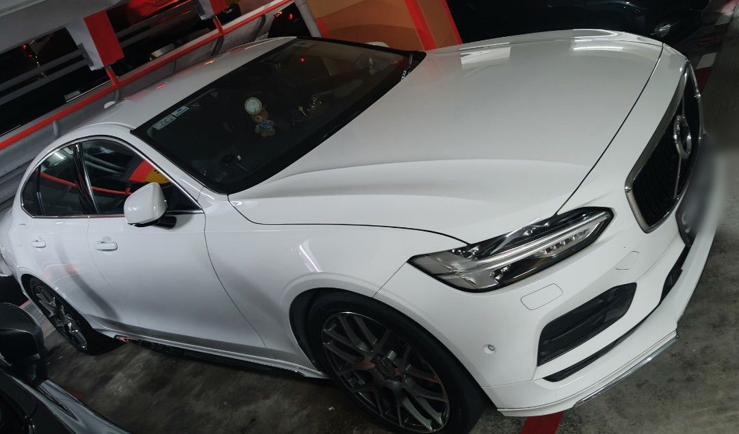 Volvo S90 T5 Momentum (A) (Category: Used Cars) located in Singapore. Submitted by arvin53.ks (Listing ID 1467540149, Image 1). Description: White Volvo S90 sedan parked indoors. Right-hand drive layout with black leather interior upholstery and multi-spoke alloy wheels. Centre touchscreen infotainment display, digital instrument cluster, and textured floor mats installed. Clean bodywork and well-maintained cabin space..