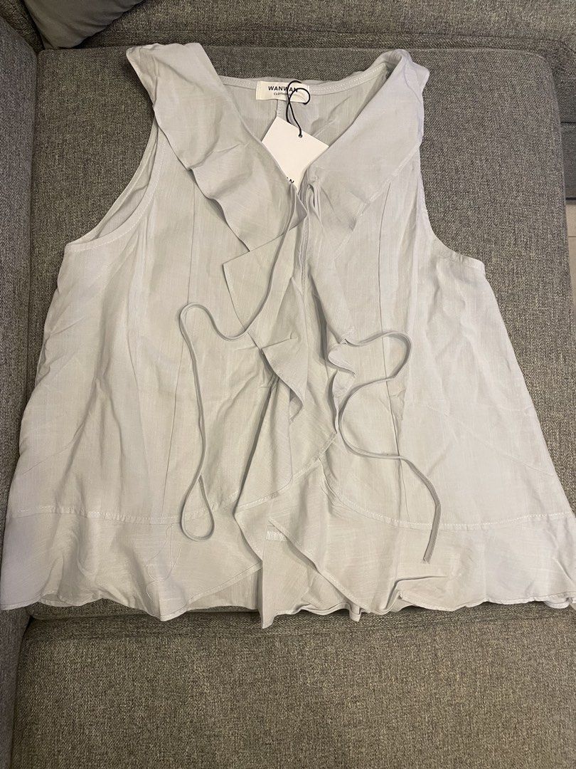Wanwan BKK Ruffle Sleeveless Top (Category: Blouses) located in Quezon City. Submitted by mfordma (Listing ID 1467371389, Image 1). Description: BRAND NEW Originally bought for 650.00 Doing a little closet decluttering! ✨ Letting go of some pieces that are still in great condition and looking for a new home. 🤍 Brand: Wanwan Clothing Size: Free size Color: Light Gray Description: - Cotton lightweight sleeveless top with a flared bottom hem - Ruff