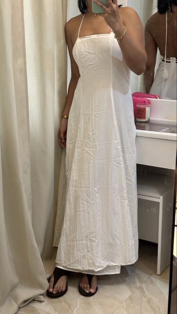 White halter neck maxi dress with open back (Category: Dresses) located in Rizal. Submitted by literally.lori (Listing ID 1467435551, Image 1). Description: - Color: White - Style: Long maxi dress with an A-line cut and floor-length design - Features: Halter neck with tie-behind straps, low open back, and cute tassel tie details - Fabric: Lightweight and comfortable - Occasion: Ideal for beach trips, vacations, and summer outings - Condition: Cle