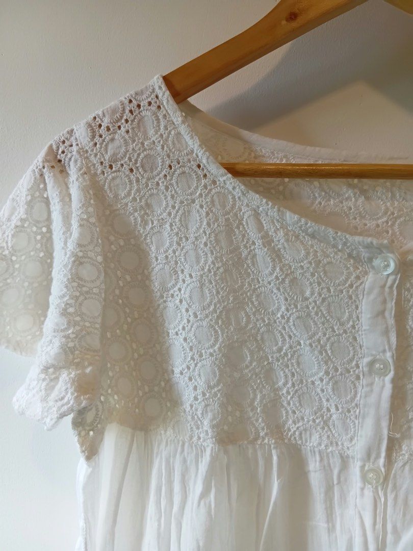 White lace trim button-up blouse top S-M (Category: Blouses) located in Antipolo. Submitted by wisecat.4a7eea (Listing ID 1467401246, Image 3). Description: - Color: White - Fit: Comfortably fits Small to Medium - Material: Lightweight gathered fabric - Design: Cut-out lace yoke and sleeves, front button closure - Details: Matching buttons and crocheted lace trim along the bottom hem - Styling: Great basic piece for warm weather, easy to pair wit