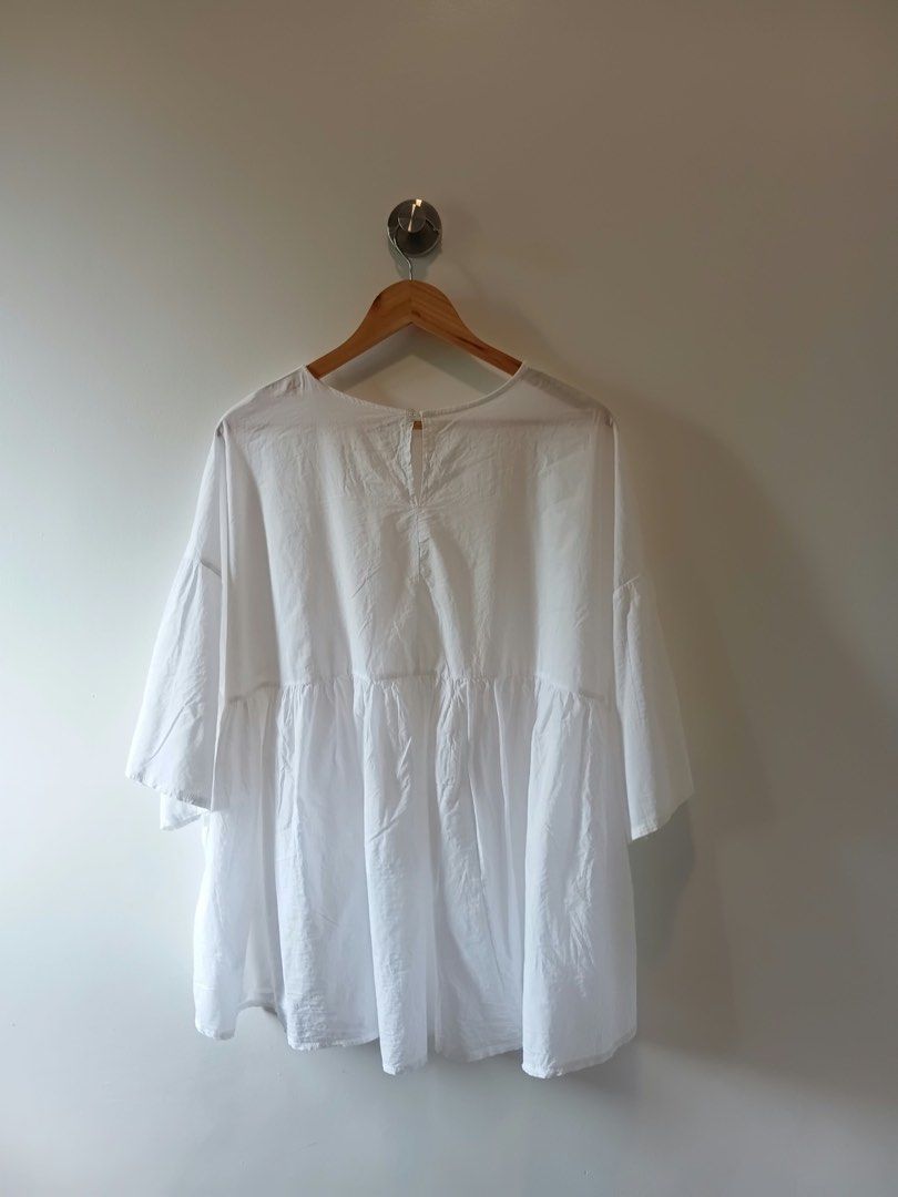 White Peplum Blouse Shirt (Category: Blouses) located in Antipolo. Submitted by wisecat.4a7eea (Listing ID 1467402344, Image 2). Description: - Color: White - Style: Oversized peplum blouse with a trendy high-low tiered hemline - Material: Lightweight, breathable cotton for everyday comfort - Details: Dropped shoulders, half sleeves, and back button closure - Fit: Roomy and relaxed; best fits Large to Extra Large (L-XL).
