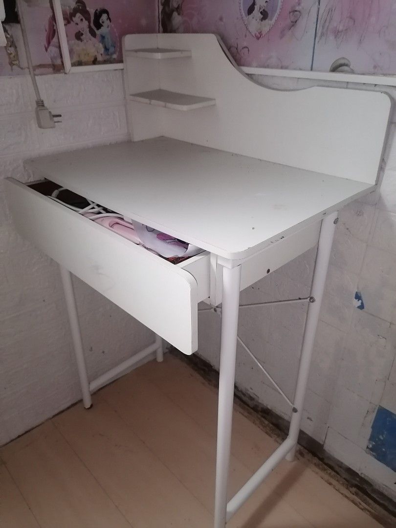 White study desk with built-in shelves and drawer (Category: Office Furniture & Fixtures) located in Manila. Submitted by yzekielshop (Listing ID 1467390841, Image 2). Description: - Color & Finish: Clean white finish throughout - Material: Sturdy white tabletop with durable metal frame legs - Storage Features: Includes a wide pull-out drawer under the main desk and two small upper shelves for decor or books - Space-Saving: Compact design, perfec