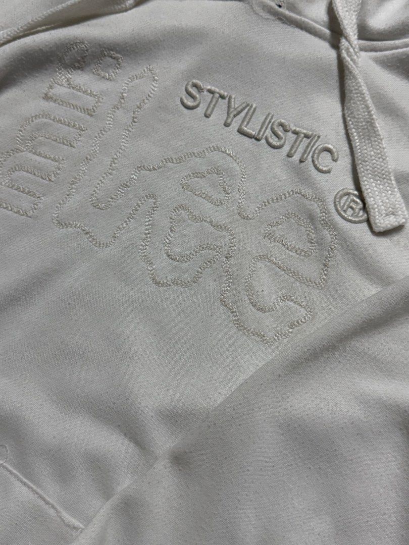White Stylistic Hooded Sweatshirt (Category: Hoodies) located in Taguig. Submitted by wornbyjmag (Listing ID 1467470180, Image 2). Description: - Color: White - Design: Textured embroidered 'Stylistic' lettering on the chest - Features: Kangaroo pocket and adjustable drawstring hood - Fit: Ribbed cuffs and hem to maintain shape - Comfort: Soft cotton blend interior for warmth and cozy feel - Condition: Brand new / Excellent quality - Mode of Paym