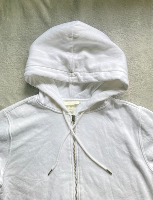 White Zip-Up Hoodie (Category: Coats, Jackets and Outerwear) located in Rizal. Submitted by sheeraay (Listing ID 1467465667, Image 3). Description: - Brand: H&M - Size: Medium (Regular fit) - Color: Clean White - Material: Cotton blend with soft fleece lining - Details: Silver-toned metal zipper, matching drawstrings with metal aglets, and double-layer hood.