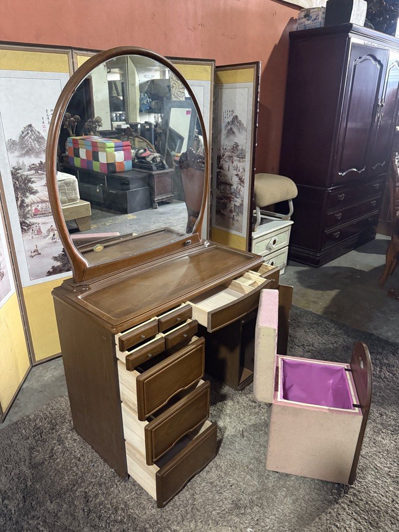 Wooden Vanity Table With Oval Mirror And Storage Stool (Category: Tables & Sets) located in Angeles City. Submitted by maryannmar33098 (Listing ID 1467513500, Image 3). Description: Wooden vanity set with a large oval mirror. Plenty of storage space here: six small drawers up top, three deep drawers on the left, a side cabinet, plus a matching storage stool with a lift-up seat lined in pink. Rich wood grain finish throughout. Built-in outlet on t
