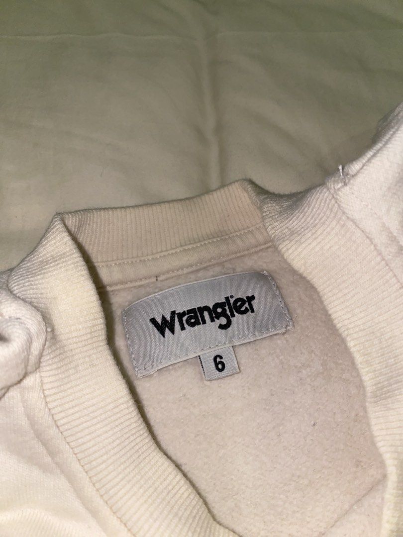 Wrangler White Embroidered Sweatshirt Size 6 (Category: Coats, Jackets and Outerwear) located in Bacoor. Submitted by sad.burrito (Listing ID 1467494924, Image 2). Description: Cozy white Wrangler sweatshirt featuring red embroidered chest branding and 'Est. 1947' detail. Size 6 with a soft fleece lining and classic ribbed trim. Perfect for casual wear. PM for inquiries! 📦 Lalamove/LBC, shipping fee shouldered by buyer 📍 Bacoor, Cavite.