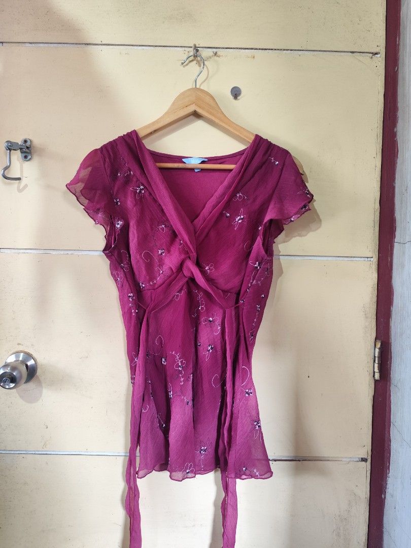 Y2k burgundy (Category: Blouses) located in Lemery. Submitted by dailythriftin (Listing ID 1467392001, Image 1). Description: - Brand: Denver Hayes - Color: Deep burgundy with white and dark floral embroidery - Style: V-neck with twisted knot front, short flutter sleeves - Fit: Lightweight, flowy, sheer fabric with side waist ties - Condition: Excellent pre-loved condition - Perfect for: Casual days, date nights, or office wear.