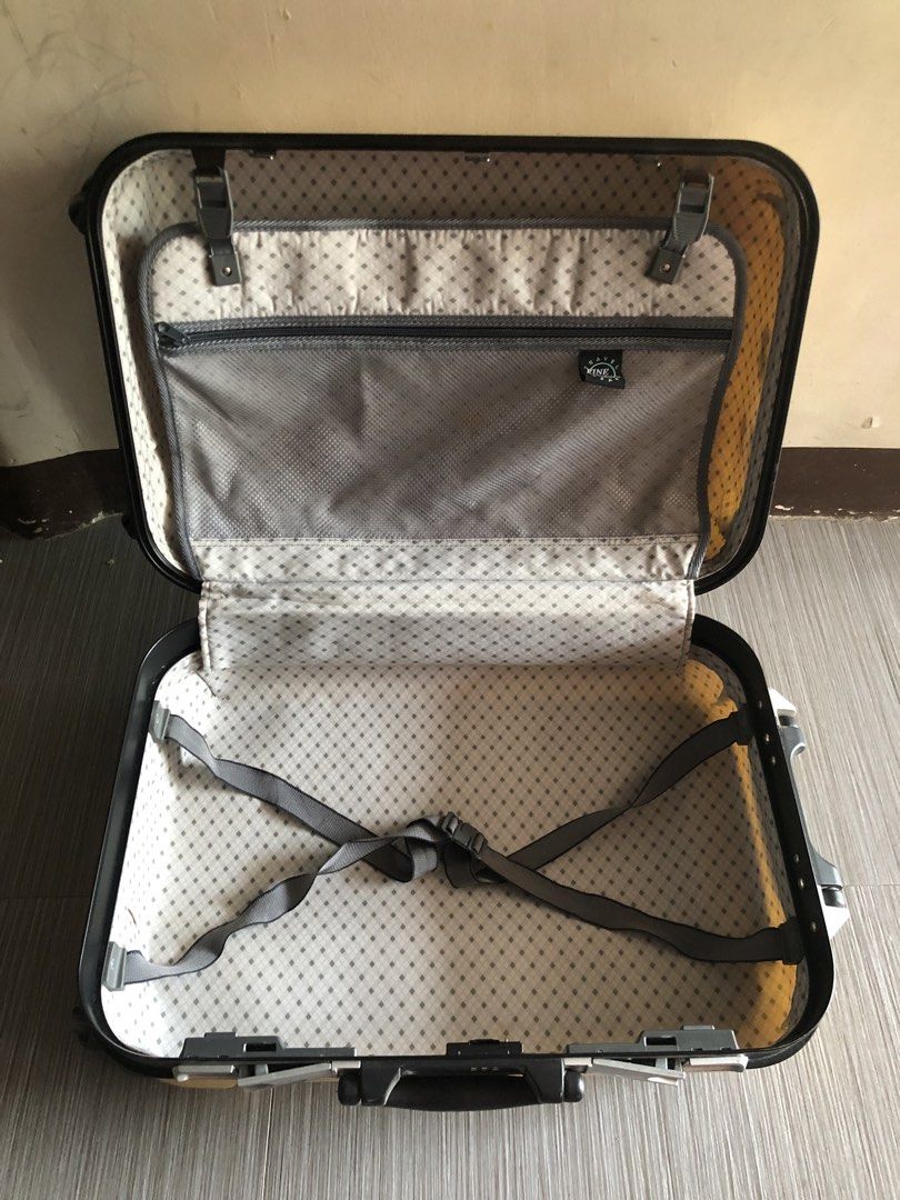 Yellow hard shell rolling suitcase with handle (Category: Luggage) located in Cavite. Submitted by ai__chang (Listing ID 1467408239, Image 2). Description: - Type: Yellow hard shell suitcase - Security: Built-in side combination lock - Interior: Patterned fabric lining, zippered mesh divider pocket, and adjustable compression straps - Condition: Fully functional zipper closure, minor exterior scuffs, and a Bridgestone sticker on the front.