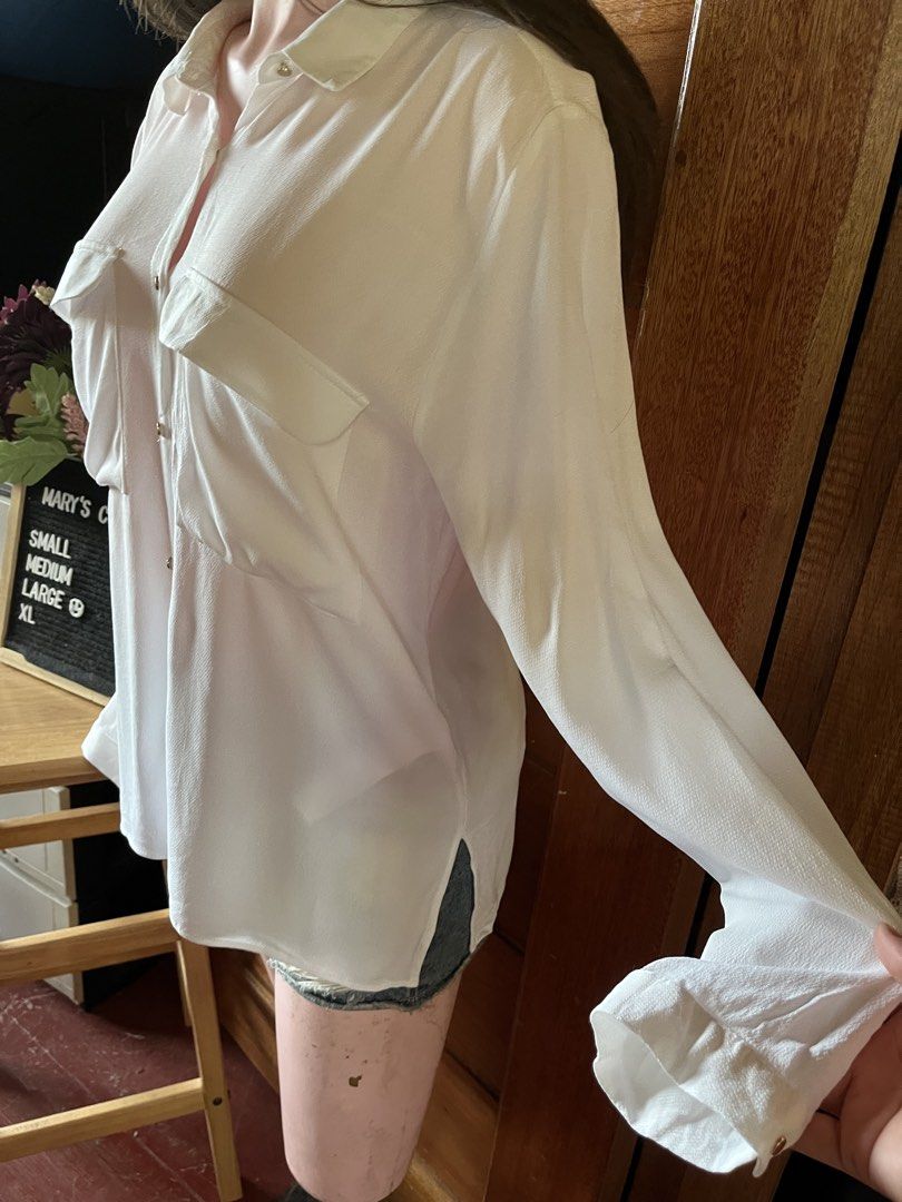 Zara Basic White Long Sleeve Button Down Shirt Size L (Category: Longsleeves) located in Tandag. Submitted by maryarlale42144 (Listing ID 1467367645, Image 2). Description: - Brand: Zara Basic - Size: L (EUR, USA, MEX) - Color: Classic White - Material: Lightweight textured fabric (slightly sheer) - Features: Classic collar, long sleeves with button cuffs, two front chest pockets, relaxed fit, curved hem with side slits - Origin: Made in Turkey -