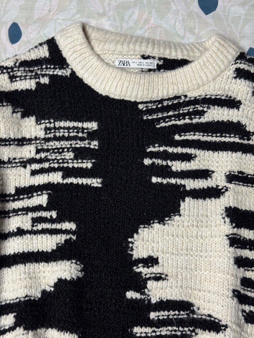 Zara Black and White Patterned Knit Sweater Size L (Category: Longsleeves) located in Manila. Submitted by seangoart (Listing ID 1467438983, Image 2). Description: - Brand: Zara - Size: Large (L) - Design: Striking black and white abstract pattern - Details: Crew neck with thick ribbed collar, cuffs, and hem - Origin: Made in Turkey - Condition: Warm, cozy knit material, perfect for cooler weather.