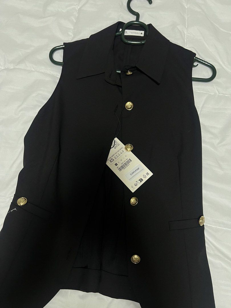 ZARA Black Vest with Gold Buttons (Category: Sleeveless) located in Cebu City. Submitted by declutteringloved (Listing ID 1467573418, Image 2). Description: - Brand: Zara - Style: Sleeveless tailored vest with a curved hemline - Color: Classic black - Details: Collar neckline, button-up front, and front flap pockets - Accents: Eye-catching shiny gold embossed buttons - Condition: Brand new with original price tag attached - Fit: Tailored, sleek, 