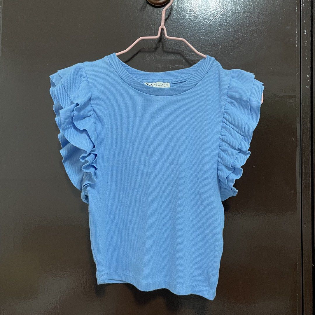 Zara Blue Ruffle Sleeve Ribbed Top Size M (Category: Sleeveless) located in Pasay City. Submitted by lovedbyzea (Listing ID 1467525965, Image 1). Description: - Brand: Zara - Size: M - Color: Light Blue - Material: Stretchy cotton blend knit - Details: Crew neckline, short layered ruffle sleeves - Condition: Clean, no stains or loose threads - Origin: Made in Bangladesh.