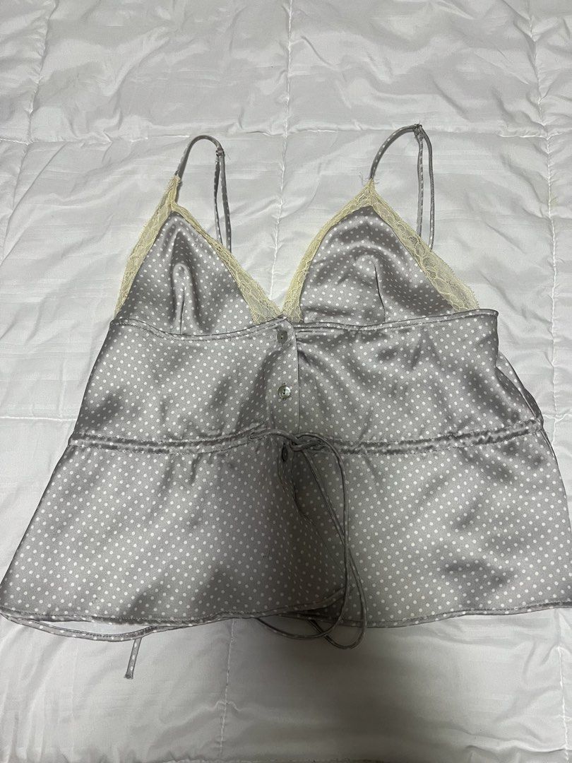ZARA Polka Dot Satin Camisole Top (Category: Sleeveless) located in Cebu City. Submitted by declutteringloved (Listing ID 1467572467, Image 2). Description: - Brand: Zara - Size: XS - Condition: Brand new with original retail tags attached - Color/Pattern: Grey with white polka dots - Material/Finish: Elegant satin - Details: Lace-trimmed V-neckline, front button placket, and waist drawstring tie - Straps: Adjustable spaghetti straps.