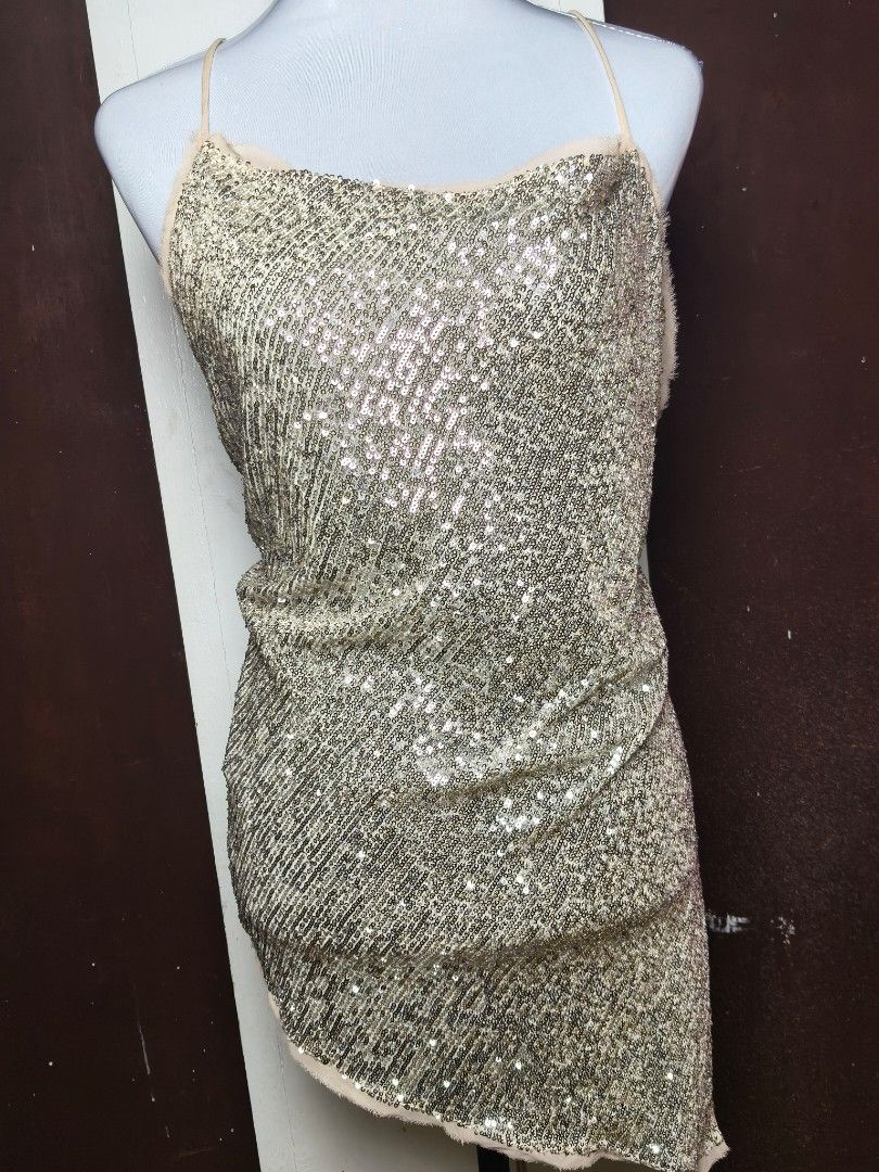 Zara Sequined Gold Halter Top (Category: Sleeveless) located in Manila. Submitted by ashie_clothing (Listing ID 1467164192, Image 1). Description: - Brand: Zara - Condition: Brand new with tags (BNWT), unworn - Size: Medium (true to size) - Color: Gold with heavy sequin detailing - Design: Halter neck, delicate spaghetti straps, and trendy asymmetrical hem - Material: Textured fabric base with full sequin overlay - Origin: Made in Morocco.