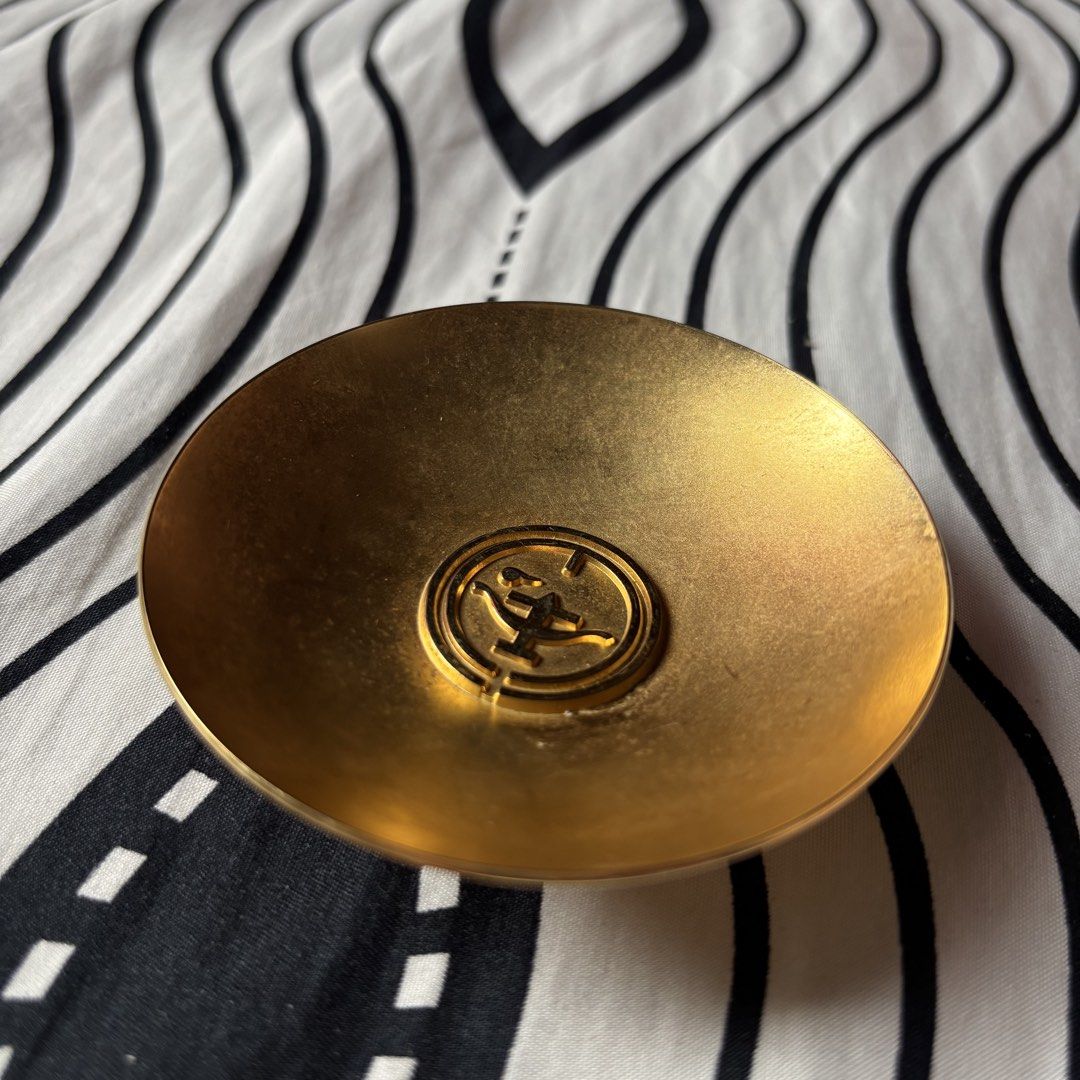 24K Gold Plated Small Bowl Dish (Category: Dinnerware & Cutlery) located in Manila. Submitted by tiffanyyyy09 (Listing ID 1467741686, Image 3). Description: - Type: Small decorative bowl - Finish: Brushed interior, shiny polished exterior and base - Material: Sturdy metal stamped with 24K GP on the bottom - Design: Circular shape with a raised interior medallion and traditional stylized center emblem - Condition: Excellent with minimal surface sc