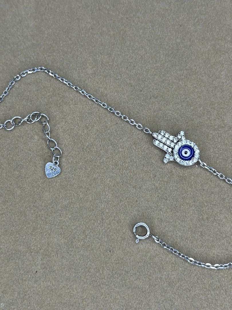 925 Sterling Silver Hamsa Hand Evil Eye Bracelet (Category: Bracelets) located in Bulacan. Submitted by vintagetreasureby.mivida (Listing ID 1467641355, Image 2). Description: - Material: Genuine 925 sterling silver - Design: Hamsa hand charm with blue and white evil eye - Details: Paved with sparkling cubic zirconia stones and a tiny stamped heart charm on the extension - Closure: Secure spring ring clasp - Fit: Adjustable length for a comfortab