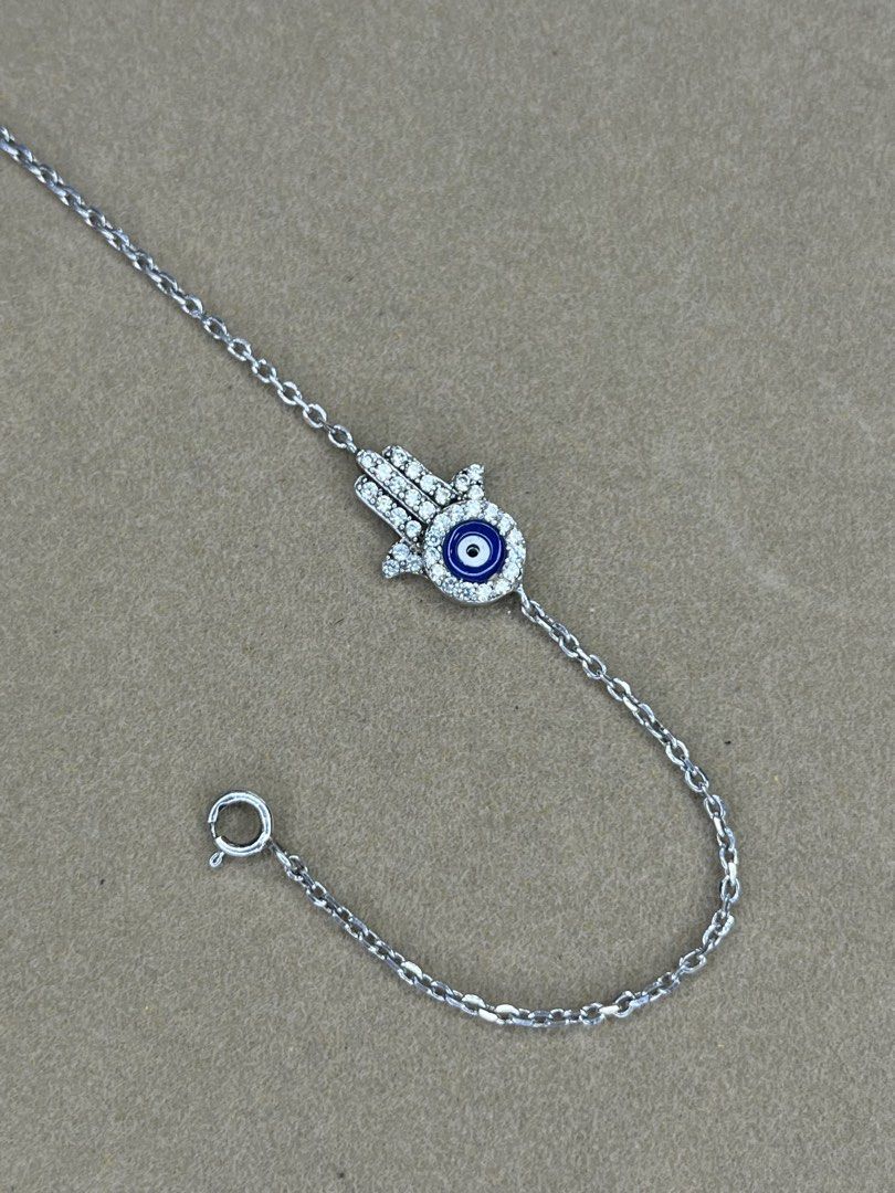925 Sterling Silver Hamsa Hand Evil Eye Bracelet (Category: Bracelets) located in Bulacan. Submitted by vintagetreasureby.mivida (Listing ID 1467641355, Image 3). Description: - Material: Genuine 925 sterling silver - Design: Hamsa hand charm with blue and white evil eye - Details: Paved with sparkling cubic zirconia stones and a tiny stamped heart charm on the extension - Closure: Secure spring ring clasp - Fit: Adjustable length for a comfortab