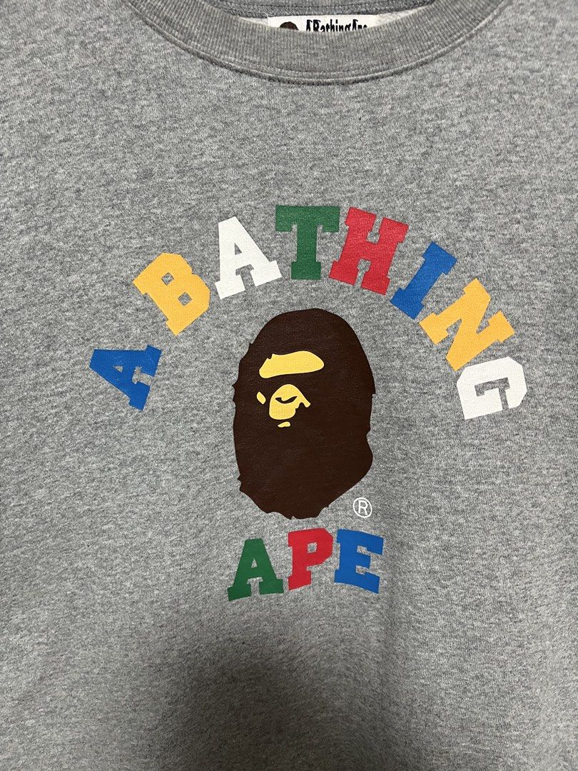 A Bathing Ape Grey Multi-Color Logo Sweatshirt (Category: Coats, Jackets and Outerwear) located in Tanza. Submitted by feliciano4108 (Listing ID 1467798434, Image 2). Description: - Brand: A Bathing Ape (BAPE) - Color: Grey with multi-color striped ribbing (red, green, yellow, black, blue) - Design: Colorful lettering graphic and iconic ape head logo on chest - Condition: Excellent, includes original neck tag and gold ape head wash tag - Authenti