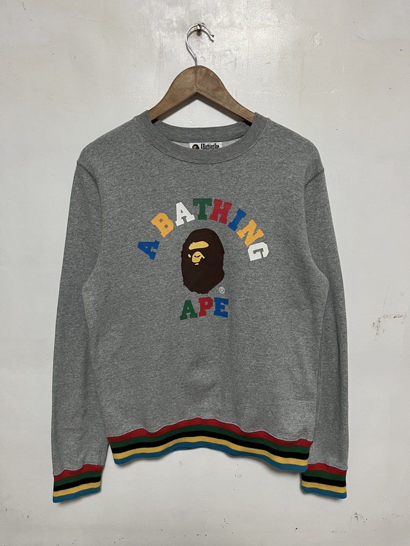 A Bathing Ape Grey Multi-Color Logo Sweatshirt (Category: Coats, Jackets and Outerwear) located in Tanza. Submitted by feliciano4108 (Listing ID 1467798434, Image 1). Description: - Brand: A Bathing Ape (BAPE) - Color: Grey with multi-color striped ribbing (red, green, yellow, black, blue) - Design: Colorful lettering graphic and iconic ape head logo on chest - Condition: Excellent, includes original neck tag and gold ape head wash tag - Authenti