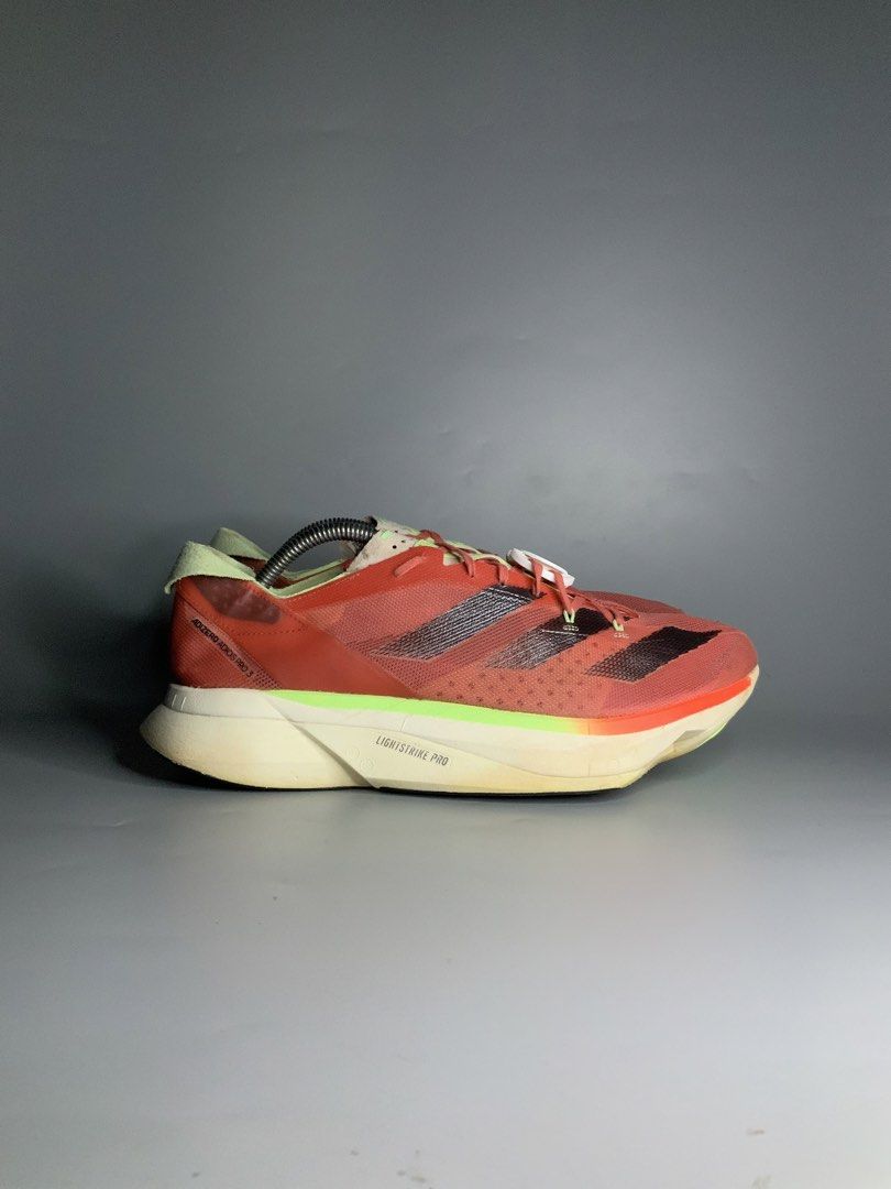 Adidas Adizero Adios Pro 3 (Category: Sneakers) located in Cavite. Submitted by kalye_footwear (Listing ID 1467771333, Image 2). Description: - Brand/Model: Adidas Adizero Adios Pro 3 - Us 10.5 , Euro 44.5 , Cm 28.5 - Colorway: Solar red upper with black three stripes and lime green accents - Technology: Lightstrike Pro cushioning foam for elite energy return - Purpose: High-performance marathon racers built for speed - Condition: Moderate wear o