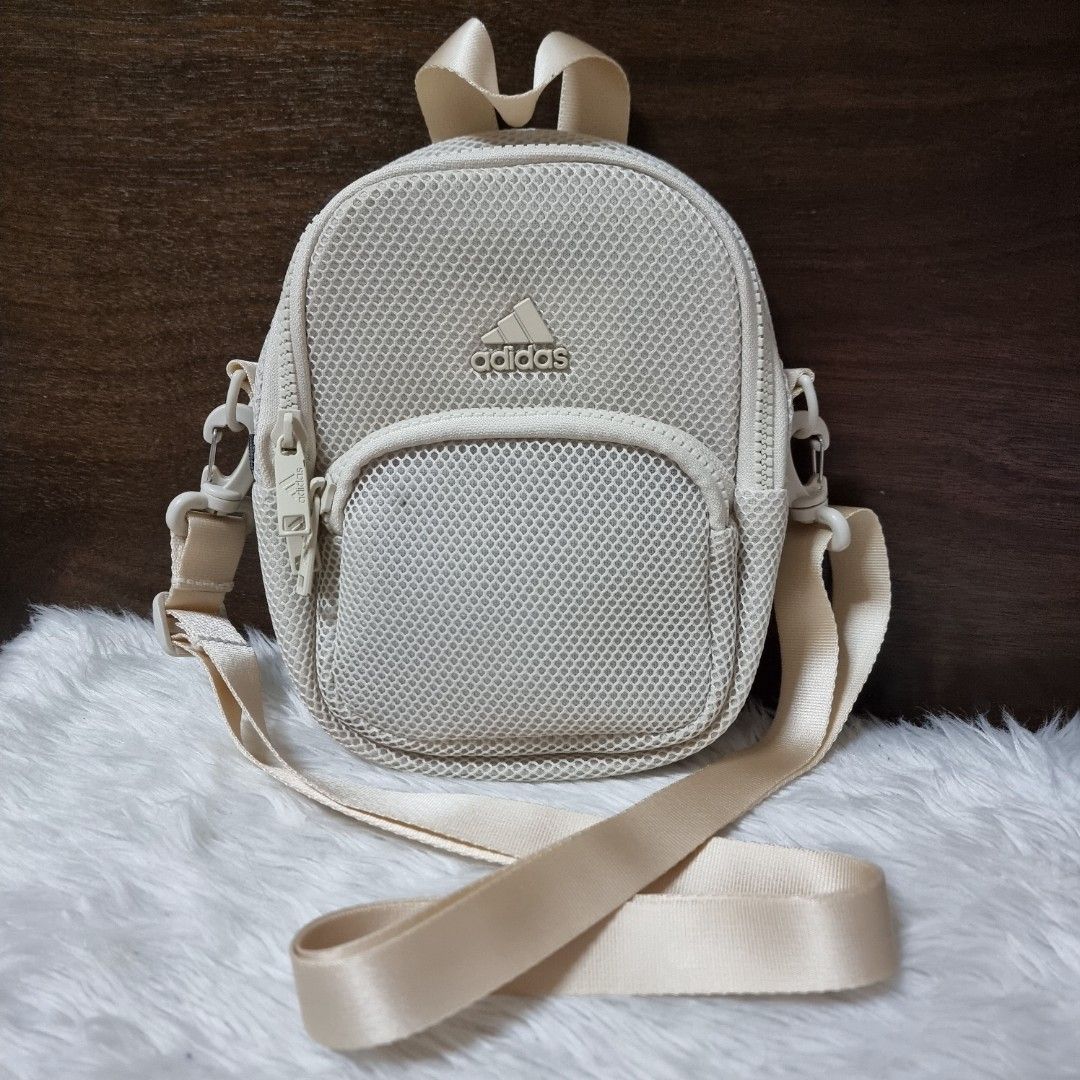 Adidas Cream Mesh Mini Backpack Crossbody Bag (Category: Backpacks) located in Manila. Submitted by fashiondera. (Listing ID 1467644272, Image 1). Description: - Brand: Adidas - Color: Cream - Style: Mini backpack / Convertible crossbody - Material: Mesh texture outer shell - Features: Main zipper compartment, front pocket, inner slip pocket, top handle - Straps: Adjustable and versatile for multiple wear styles - Condition: Clean interior lining