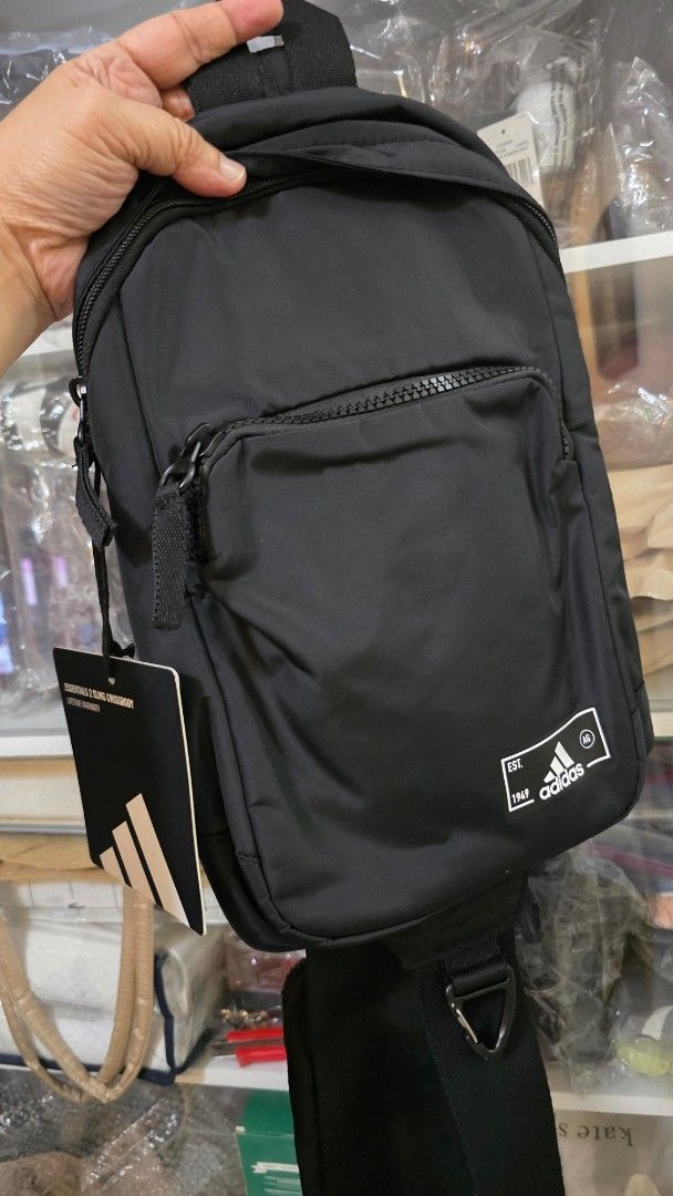 Adidas Essentials Sling Crossbody Bag Black (Category: Sling Bags) located in Quezon City. Submitted by momof3_11 (Listing ID 1467759068, Image 1). Description: - Brand new with original store tags attached - Color: Classic black with crisp white Adidas branding patch - Storage: Secure main zippered compartment and front zip pocket - Hardware: Durable adjustable strap - Size: Compact everyday carry, ideal for phone, wallet, and keys.