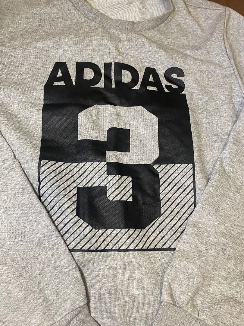 Adidas Grey Graphic Sweatshirt (Category: Coats, Jackets and Outerwear) located in San Pablo. Submitted by kisha_santonia (Listing ID 1467666343, Image 3). Description: - Authentic grey Adidas crewneck sweatshirt - Bold chest graphic featuring 'ADIDAS' and large number 3 in a block pattern - Small Adidas logo printed near the bottom hem - Comfortable fleece lining for extra warmth - Classic ribbed cuffs, collar, and hem - Ideal for casual, everyd