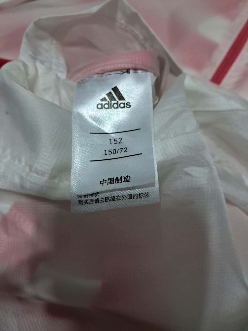 Adidas reversible Pink White Striped windbreaker Jacket (Category: Coats, Jackets and Outerwear) located in Baguio. Submitted by padisellsz (Listing ID 1467729031, Image 2). Description: - Brand: Adidas - Very good condition - slight stain washable - Color: Pink with white stripes - Size: 152 / fits XS to S (18" x 23.5" flat lay measurements) - Features: Full zip closure, attached hood, and large Adidas logo printed down the right sleeve - Materi