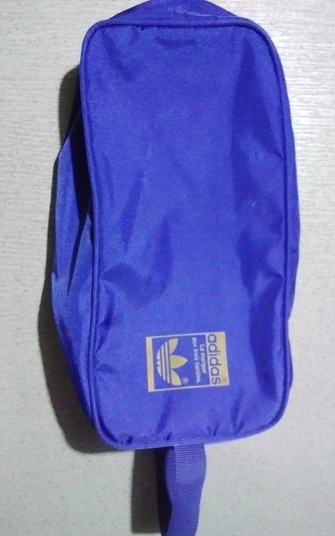 Adidas shoe bags (Category: Announcements) located in Quezon City. Submitted by Bernz (Listing ID 1467723857, Image 2). Description: This is a vintage Adidas Originals shoe bag (or boot bag) featuring a retro "The Team" design. Key Features Design Elements: It displays the classic Trefoil logo, the slogan "Die Weltmarke mit den drei Streifen" (The brand with the three stripes), and text reading "THE TEAM" running vertically along the front.Functi