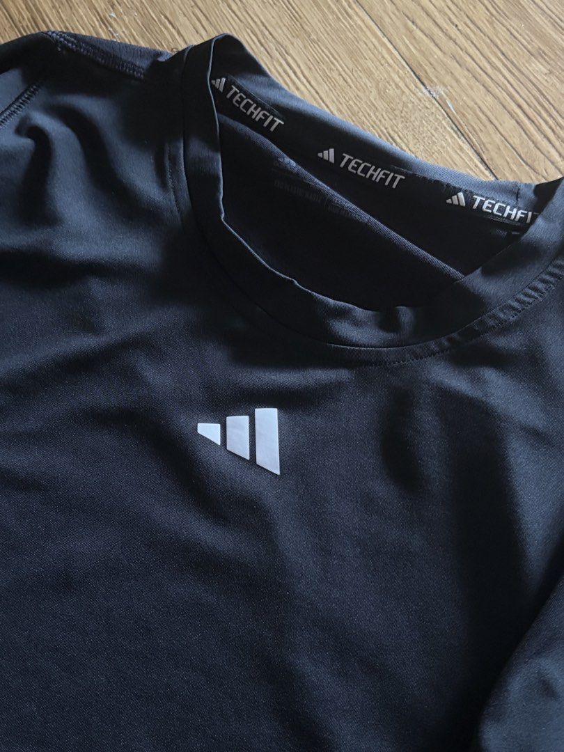 Adidas Techfit Black Long Sleeve Compression Shirt (Category: Activewear) located in Taguig. Submitted by wornbyjmag (Listing ID 1467608635, Image 2). Description: - Brand: Adidas - Style: Techfit long sleeve compression shirt - Color: Black with white Adidas performance logo - Neckline: Crew neck with ribbed trim and Techfit collar tape - Fit: Form-fitting - Ideal for: Workouts, gym sessions, or layering under jerseys.
