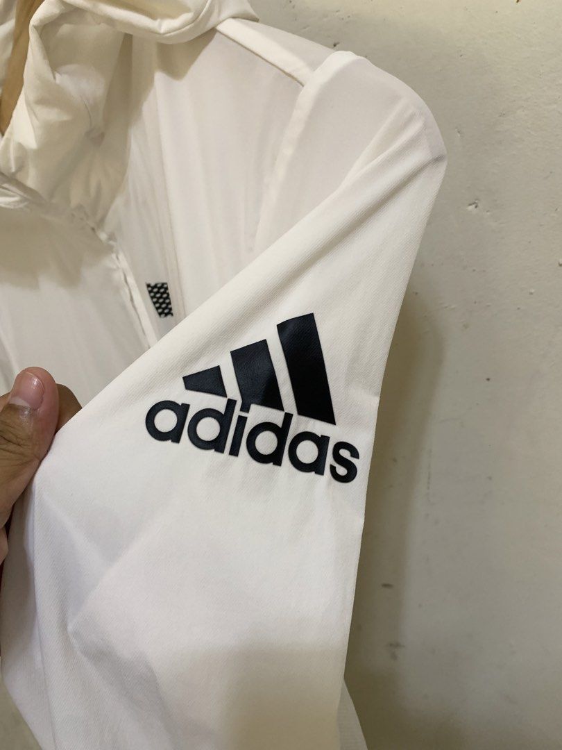 Adidas White Windbreaker Jacket with Bold Logo (Category: Coats, Jackets and Outerwear) located in Davao. Submitted by psg_ninyo (Listing ID 1467611435, Image 3). Description: - Brand: Adidas - Style: Windbreaker jacket with attached hood - Color: White with bold black ADIDAS print along the front zipper and logo on the left arm - Size: 165/80A - Material: Lightweight nylon and elastane shell with a polyester mesh insert - Origin: Made in China -