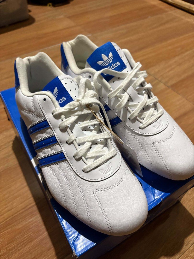 ADIRACER LO (Category: Sneakers) located in Pasig City. Submitted by styledfitsbymae (Listing ID 1467737798, Image 3). Description: - Brand: Adidas - Style: White leather sneakers with bright blue stripes and heel tabs - Details: Classic Trefoil logo on tongue and side, white front laces - Condition: Brand new, never worn, pristine condition - Inclusions: Original Adidas blue box with packing tissue - 6.5 US .