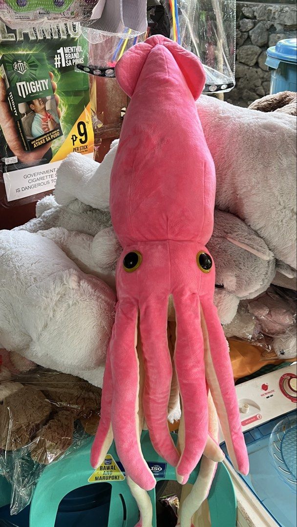 Amuse Squid Plush Toy 114cm (Category: Plushies & Soft Toys) located in San Jose del Monte. Submitted by faithyfairy_ (Listing ID 1467720098, Image 1). Description: - Size: Massive 114cm long - Design: Cute pink squid with big yellow and black round eyes and lots of soft hanging tentacles - Material: Super soft and cuddly fabric - Condition: Clean, fluffy, and ready for a new home - Perfect as a huggable companion or a fun kid-sized photo prop.