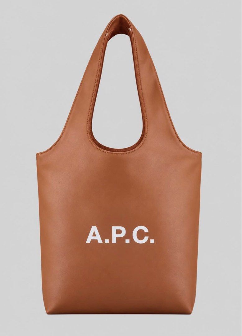 A.P.C. Leather Tote Bag (Category: Tote Bags) located in Mabalacat. Submitted by davidbianc04942 (Listing ID 1467731477, Image 2). Description: - Brand: A.P.C. - Style: Minimalist leather tote bag with a clean silhouette - Design: Bold white logo lettering centered on the front - Features: Double shoulder straps and a spacious interior for daily essentials - Colors available: Black, tan, and off-white - Material/Finish: Smooth finish.
