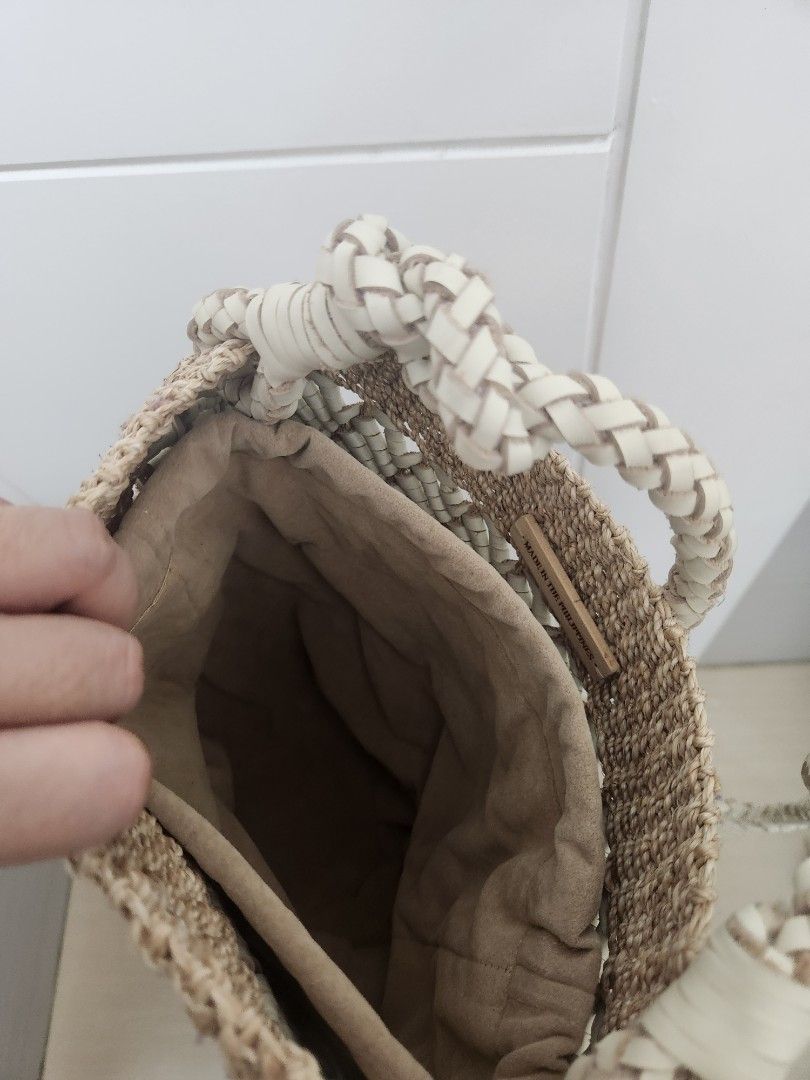 Aranaz Joy Bucket Bag (Category: Shoulder Bags) located in Makati City. Submitted by mikamix (Listing ID 1467604320, Image 3). Description: - Brand: Aranaz - Style: Joy Bucket Bag - Origin: Handcrafted in the Philippines - Material: Woven straw and premium leather - Color: Neutral beige and white - Details: Braided shoulder strap with decorative knot, drawstring fabric lining, and metal brand logo plaque - Condition: Excellent - Perfect for: Casu