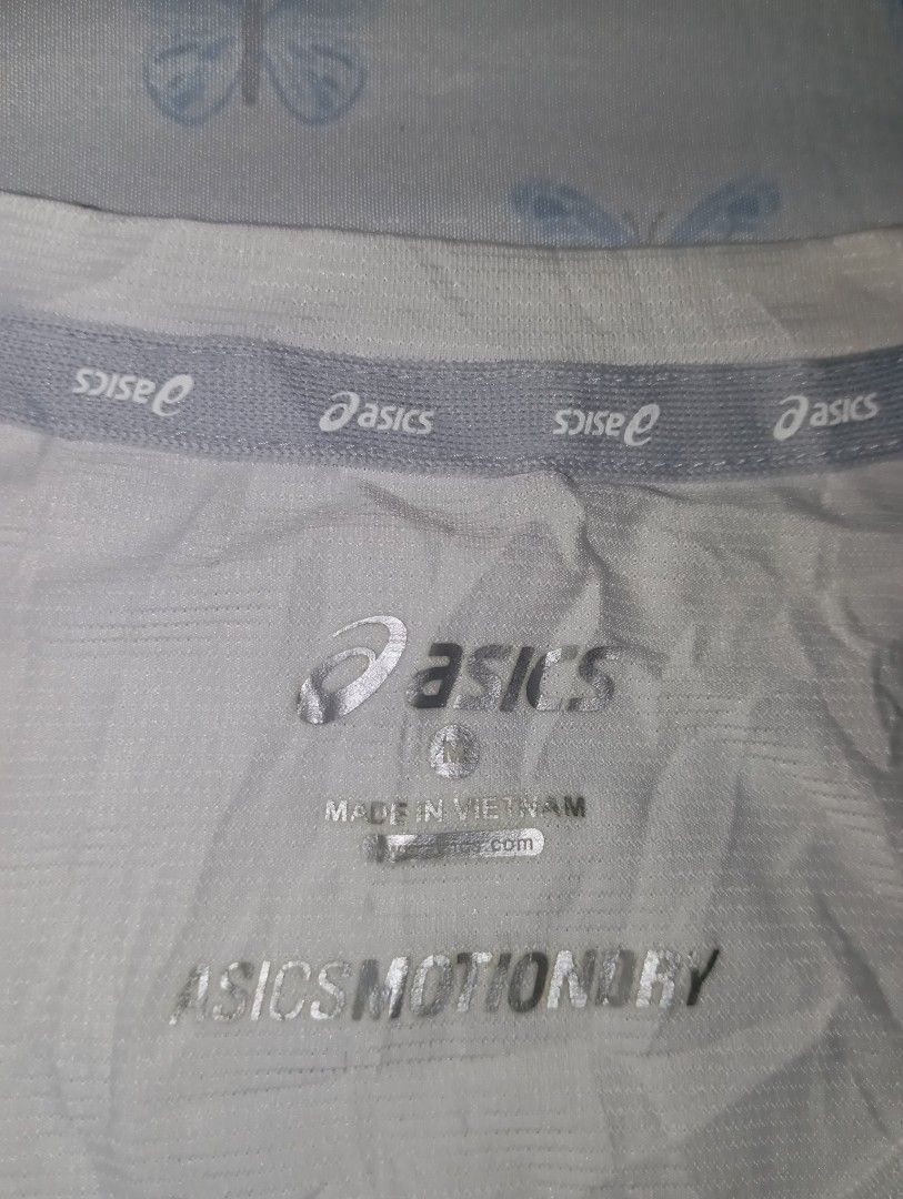Asics MotionDry Athletic Training T-Shirt Size M (Category: Activewear) located in Manila. Submitted by brugodoy (Listing ID 1467797436, Image 3). Description: - Brand: Asics - Size: Medium (M) - Color: White with grey mesh side panels - Features: Short sleeves, crew neck, reflective piping on shoulders for visibility - Origin: Made in Vietnam - Condition: Excellent, ready to wear.
