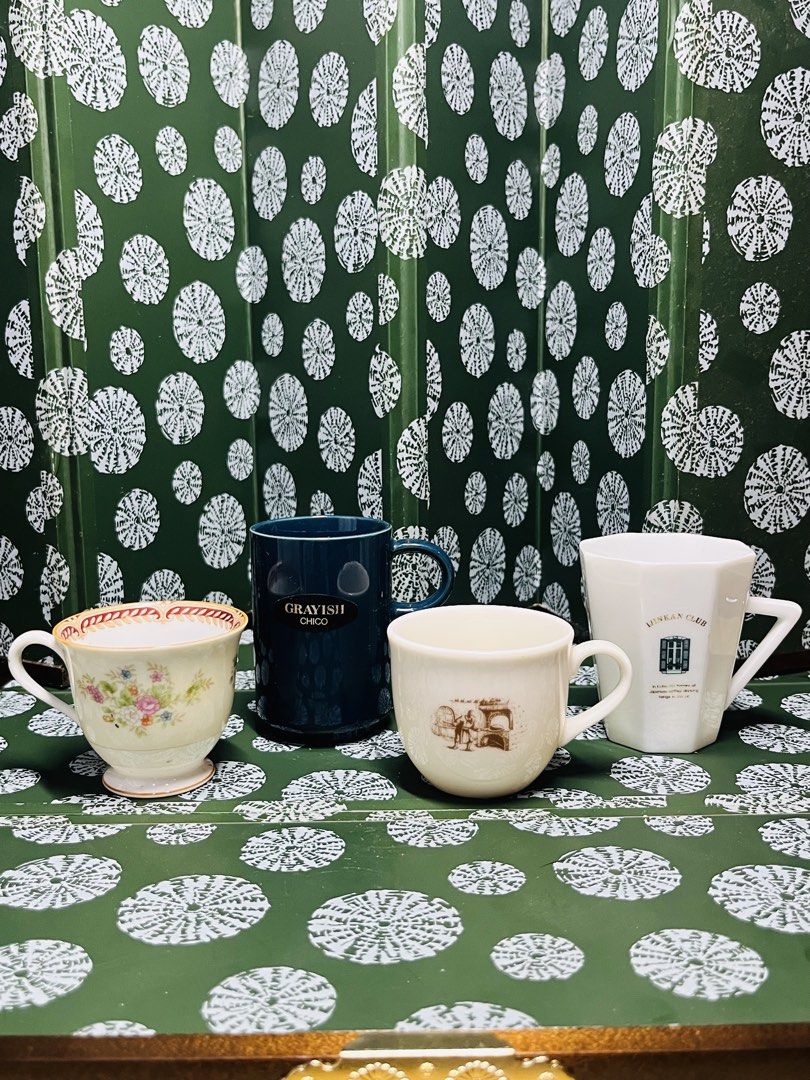 Assorted ceramic coffee mugs and tea cups bundle (Category: Coffee & Tea Tableware) located in Malabon City. Submitted by mgsurplus (Listing ID 1467831096, Image 1). Description: - Set of 4 unique ceramic cups and mugs - 1x Floral patterned teacup with footed base - 1x Dark blue-grayish Chico mug with text - 1x Cream-colored mug with brown sketch graphic - 1x White faceted hexagonal Ijinkan Club mug - Great mix of styles for daily coffee or tea r
