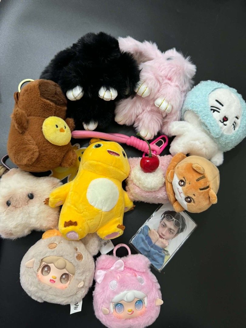 Assorted Plush Keychains and Photocard Lot (Category: Plushies & Soft Toys) located in Angeles City. Submitted by measaliman02351 (Listing ID 1467603972, Image 2). Description: - Bundle includes: Black bunny, pink bunny, yellow dinosaur, brown bear with chick, tiger, fuzzy doll heads, and an idol photocard - Material: Super soft and fluffy plush with secure metal clips - Uses: Perfect for decorating bags, keys, or display collections - Condition: