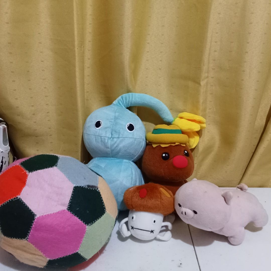 Assorted Plush Toys and Patchwork Ball (Category: Plushies & Soft Toys) located in Quezon City. Submitted by trinket_cat (Listing ID 1467679575, Image 1). Description: - Bundle of 5 cute soft items: blue bulb-headed character plush, brown creature in yellow hat, embroidered white mushroom figure, light pink pig plush, and multi-colored patchwork fabric ball - Condition: Clean overall with very minor lint collection - Perfect for cuddles, playtime