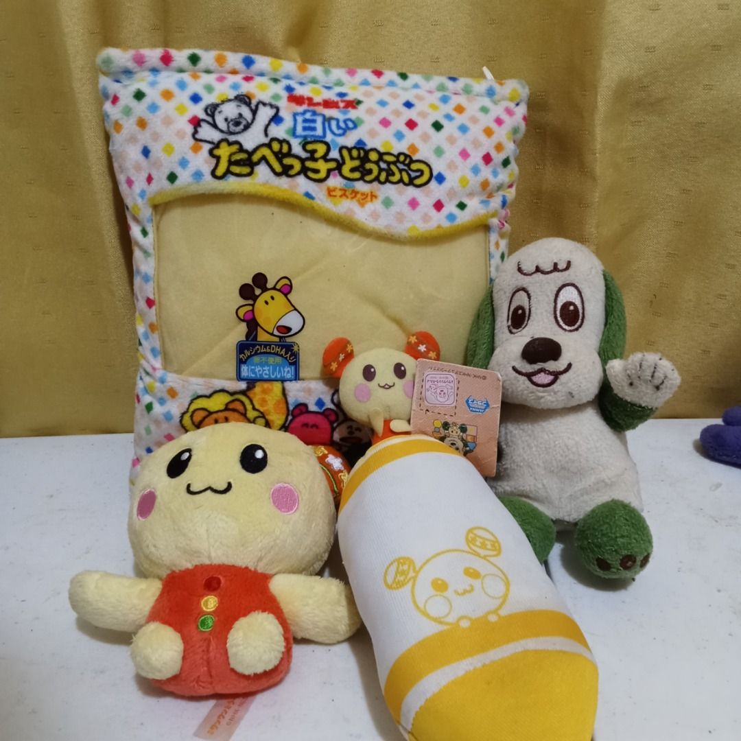 Assorted Plush Toys and Pouch Bundle Wanwan and Tamagochi (Category: Plushies & Soft Toys) located in Quezon City. Submitted by trinket_cat (Listing ID 1467678749, Image 1). Description: - Bundle of 4 cute plush items and a character pouch - Includes a white biscuit-themed pouch with colorful speckles - Small yellow character plush wearing red - Yellow and white cylindrical plush toy - White and green dog plush with a waving paw - Condition: Clea