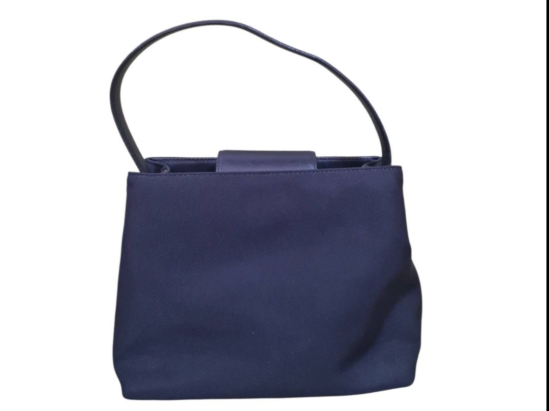 Authentic Coach Navy Blue Nylon Handbag (Category: Luxury Bags & Wallets) located in Paombong. Submitted by dosbagshop (Listing ID 1467617522, Image 2). Description: - Authentic Coach handbag in classic navy blue - Made from durable, easy-to-clean nylon material - Single leather shoulder strap with iconic metal Coach hangtag - Structured rectangular base featuring an embossed Coach logo - Stylish silver-tone hardware accents - Compact size, ideal