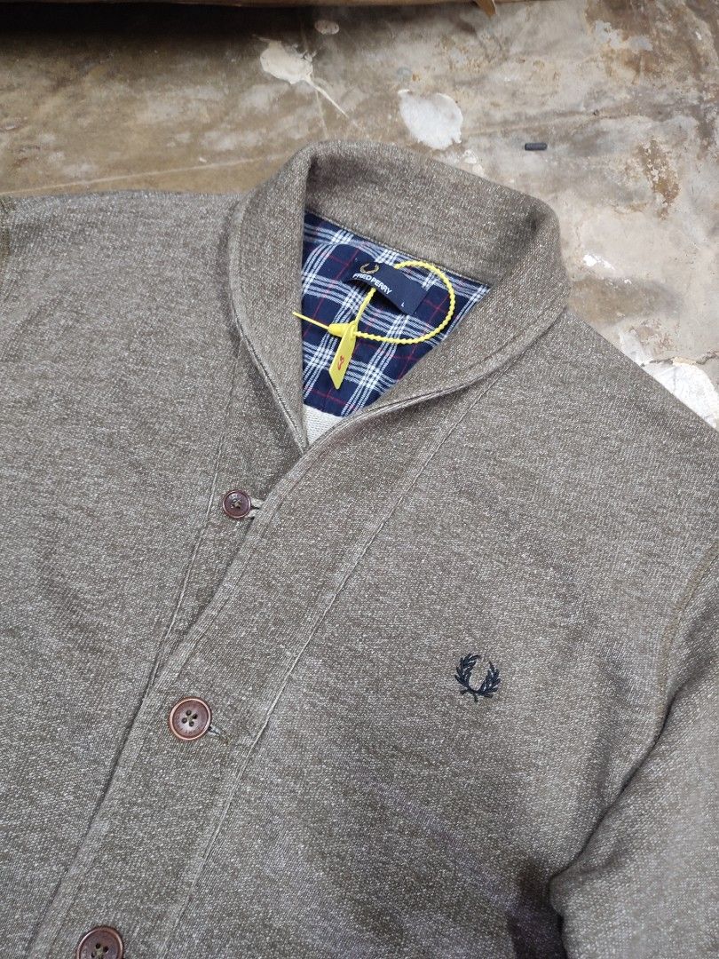 Authentic Fred Perry Shawl Collar Cardigan Grey Size L (Category: Coats, Jackets and Outerwear) located in Solana. Submitted by sonnymcamp28502 (Listing ID 1467671468, Image 3). Description: Fred Perry cardigan in grey. Size L, made in Portugal from 100 percent cotton. Shawl collar design with button-up front and front pockets. Blue plaid fabric lining inside the collar area. Laurel wreath embroidered logo on the chest. Tag still attached with pl