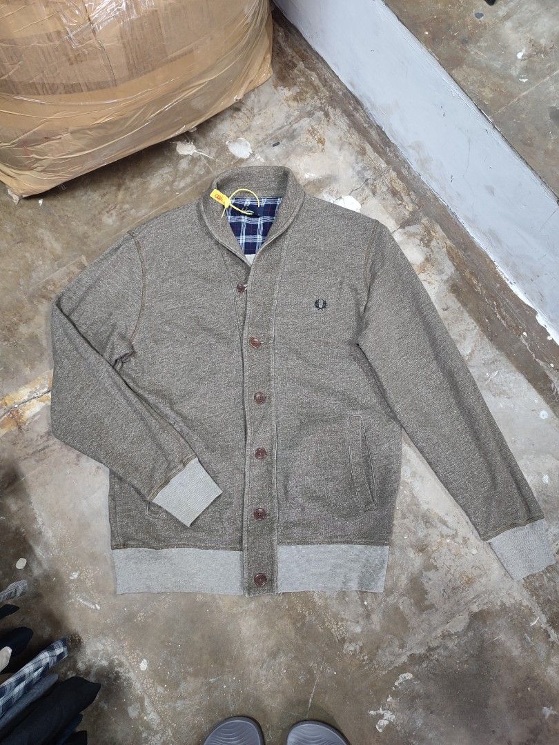 Authentic Fred Perry Shawl Collar Cardigan Grey Size L (Category: Coats, Jackets and Outerwear) located in Solana. Submitted by sonnymcamp28502 (Listing ID 1467671468, Image 2). Description: Fred Perry cardigan in grey. Size L, made in Portugal from 100 percent cotton. Shawl collar design with button-up front and front pockets. Blue plaid fabric lining inside the collar area. Laurel wreath embroidered logo on the chest. Tag still attached with pl